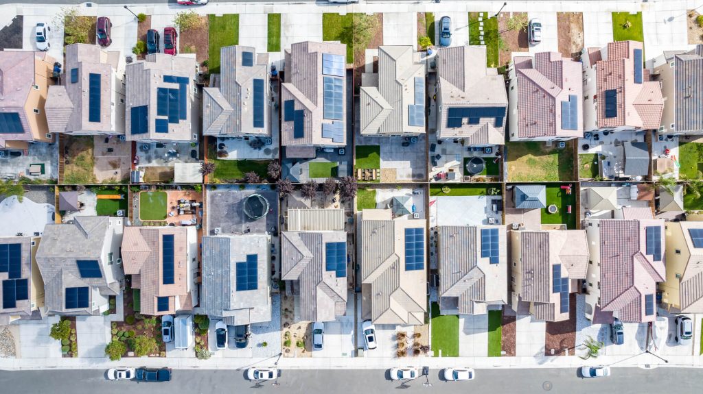 Top down view of a row of residential homes with solar panels on the roof 