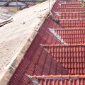Roof Replacement Trends in Brisbane – side-by-side view of old weathered roofing and newly installed red tile roofing, highlighting contrast between aged and modern roof materials.