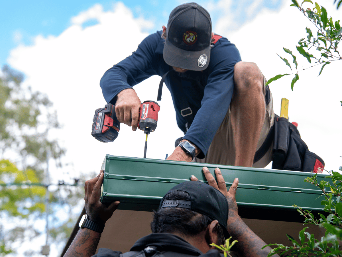 Roof repair specialists installing new gutter system for leaking roof repairs Brisbane home.