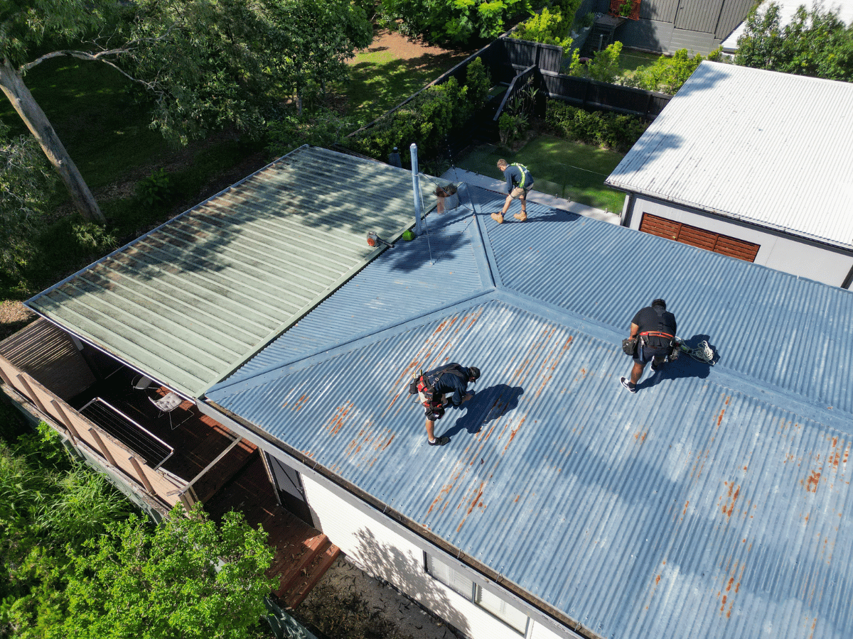 Team conducting leaking roof repairs Brisbane residential property aerial view.