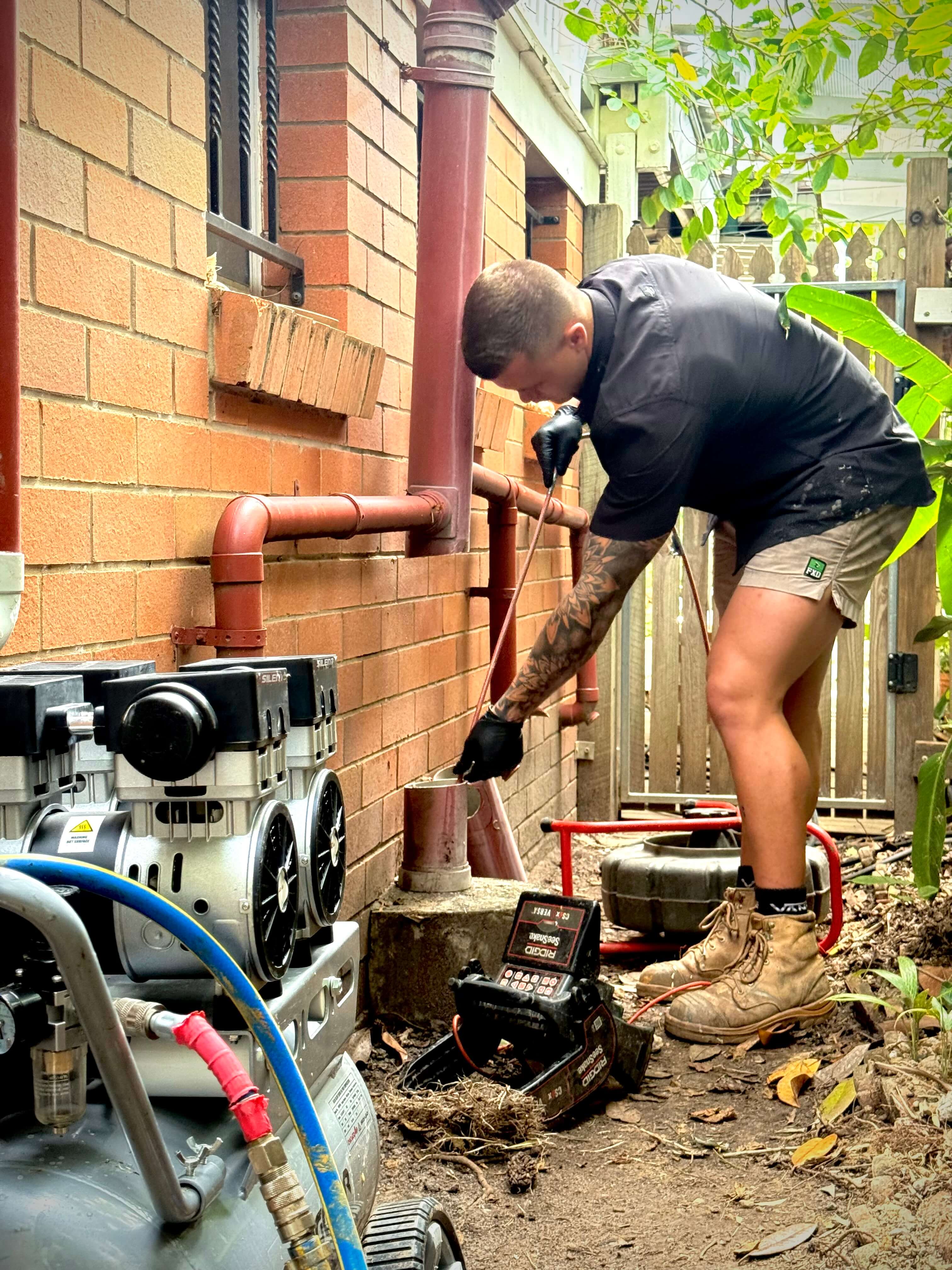 Plumber Brisbane using drain inspection camera to diagnose blocked pipes.