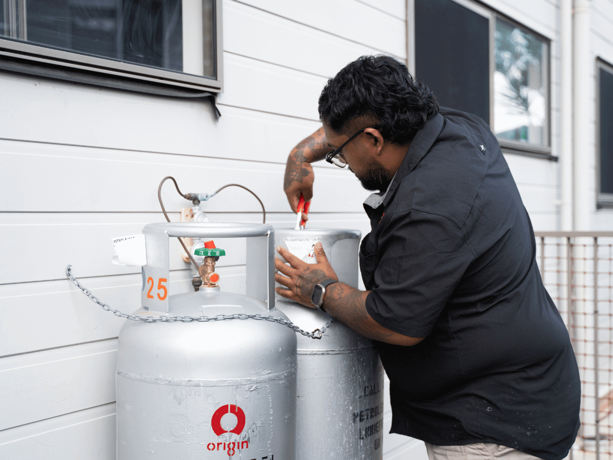 Licensed gas fitter Brisbane performing LPG cylinder installation and safety inspection.